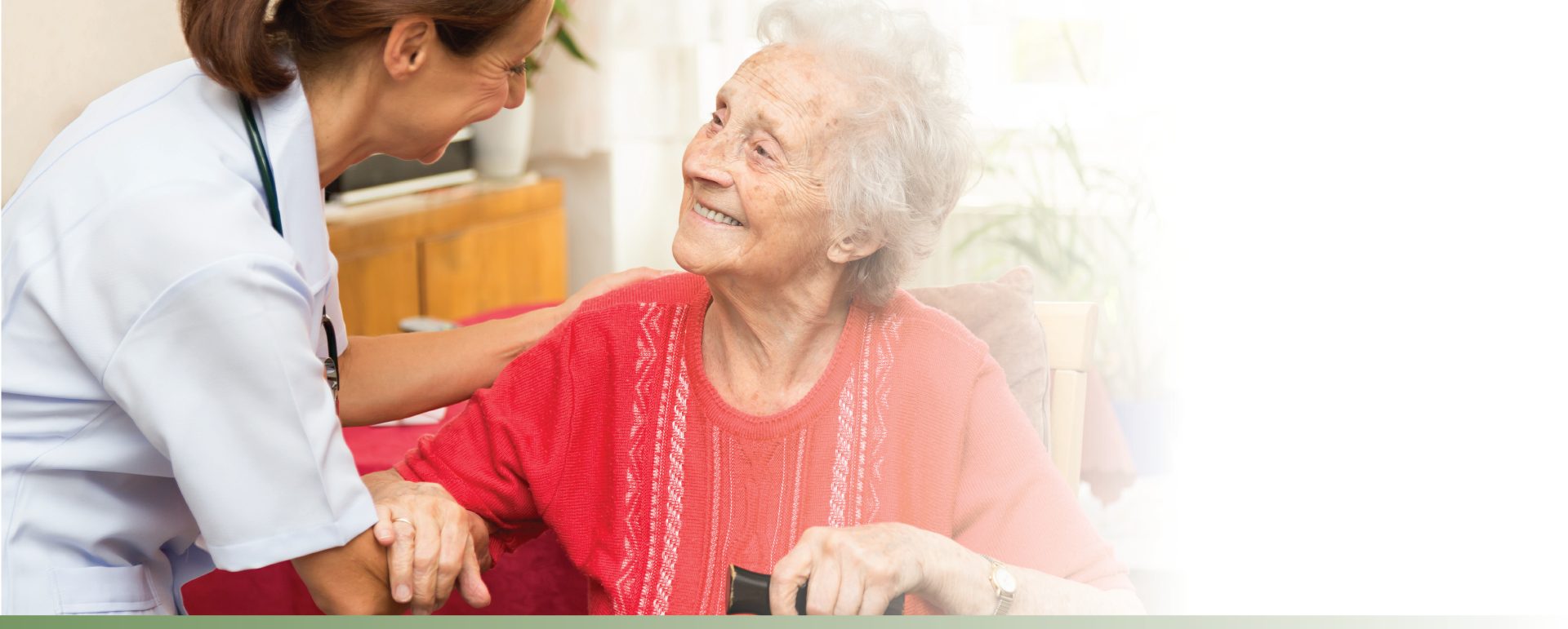 Staff member helping a senior woman to stand up