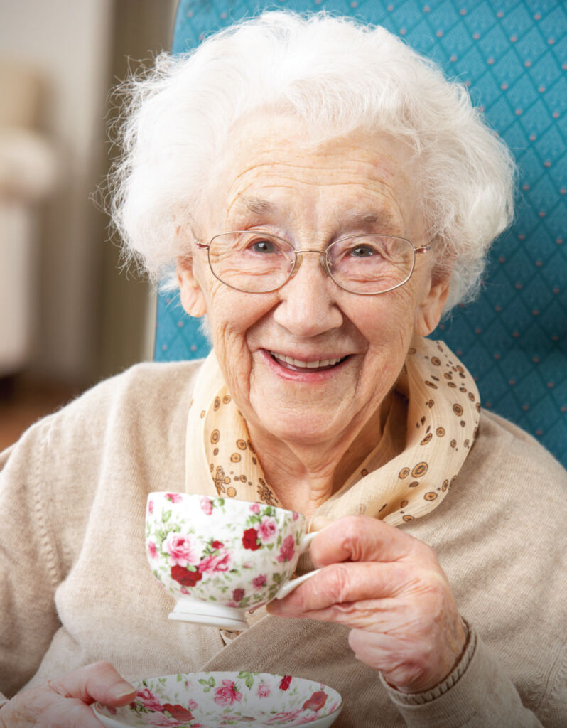 Happy senior woman drinking a warm cup of tea